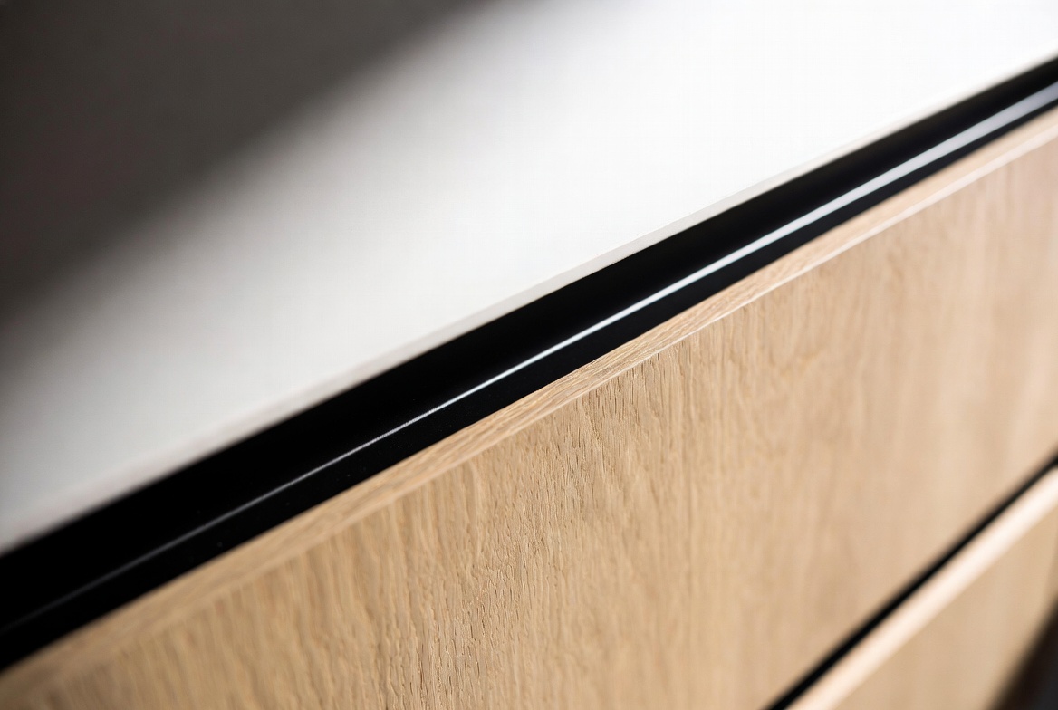 Close-up of a solid oak cabinet edge with black trim detailing
